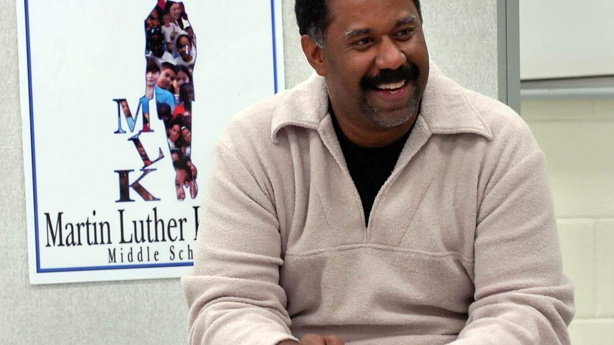 Fashion designer Cary Mitchell gives away a door prize to students before the meeting of the Martin Luther King Middle School’s Uniform Committee on Oct. 26, 2006. Mitchell worked with a group of 16 8th graders at the school to design an alternative to their plain-blue-shirts-with-khaki-pants uniforms.