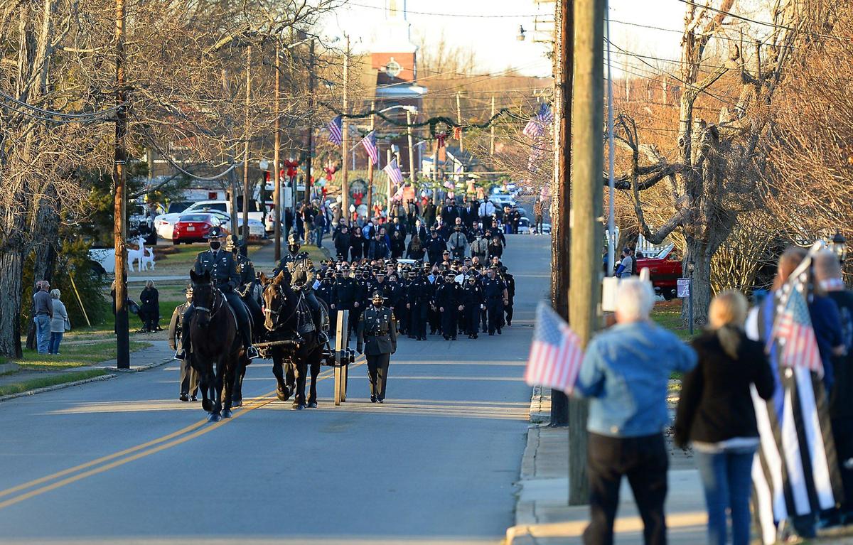 A caisson carrying the casket of fallen Concord police officer Jason Shuping travels down Main St. in Faith, NC on Tuesday, December 22, 2020. Officer Shuping was killed in the line of duty last week. The officer was responding to an attempted carjacking outside a fast food restaurant near Concord Mills.