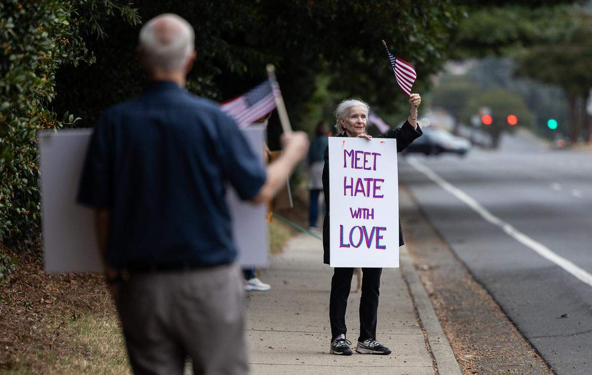 Residents of Southminster retirement community line the sidewalk of Park Road for a non-partisan patriotic march in Charlotte, N.C., on Wednesday, October 8, 2025.