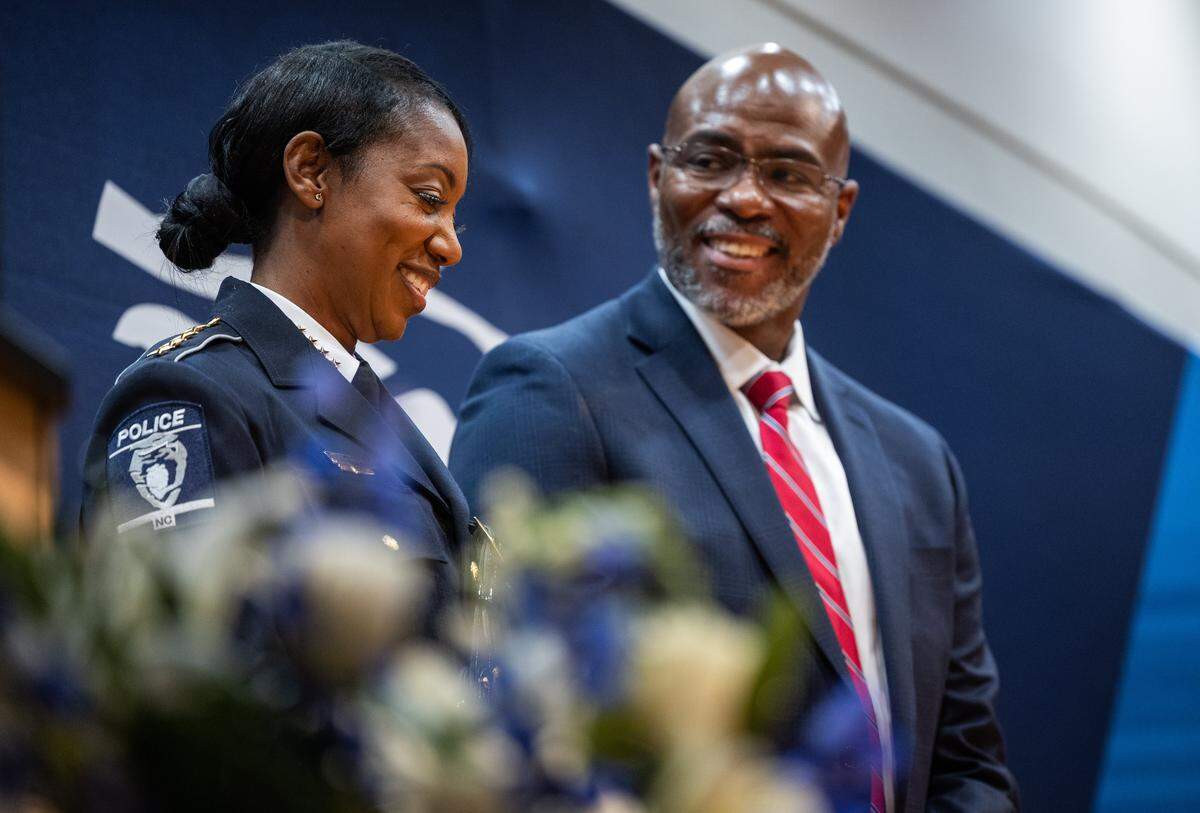 Chief Estella Patterson's husband, Lance, right, smiles at her during her swearing in ceremony at the Charlotte Police and Fire Training Academy in Charlotte, N.C., on Friday, December 5, 2025.