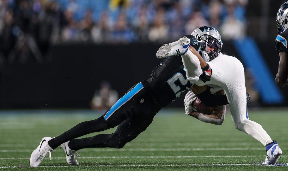 Carolina Panthers safety Alex Cook, left, tackles Indianapolis Colts wide receiver Michael Pittman Jr. at the Bank of America Stadium in Charlotte, N.C., on Sunday, November 5, 2023.