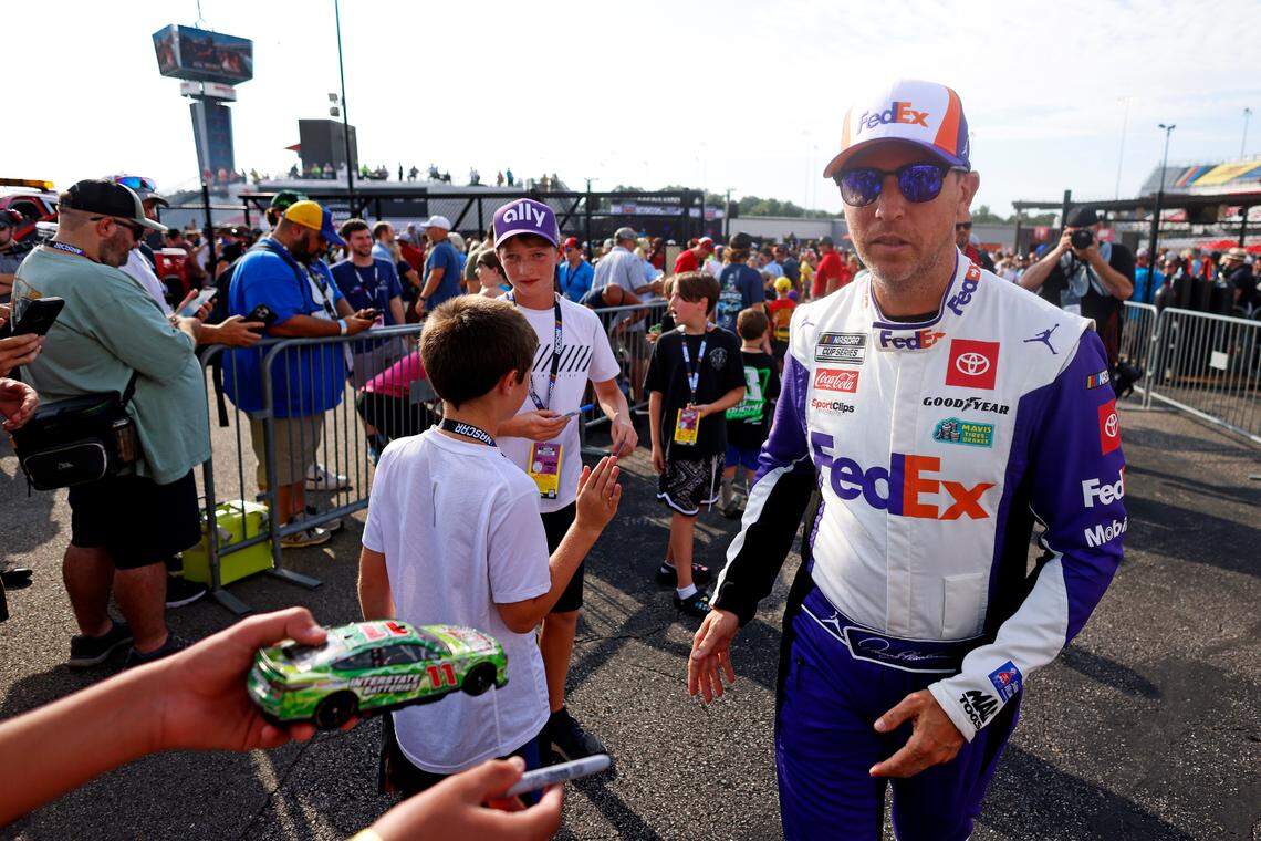 Aug 11, 2024; Richmond, Virginia, USA; NASCAR Cup Series driver Denny Hamlin (11) signs autographs before the Cook Out 400 at Richmond Raceway.