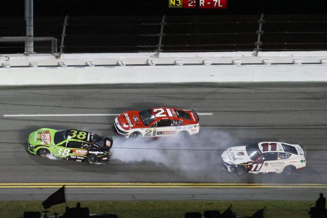 Feb 16, 2025; Daytona Beach, Florida, USA; NASCAR Cup Series driver Zane Smith (38), driver Josh Berry (21) and driver Denny Hamlin (11) wreck during the Daytona 500 at Daytona International Speedway.