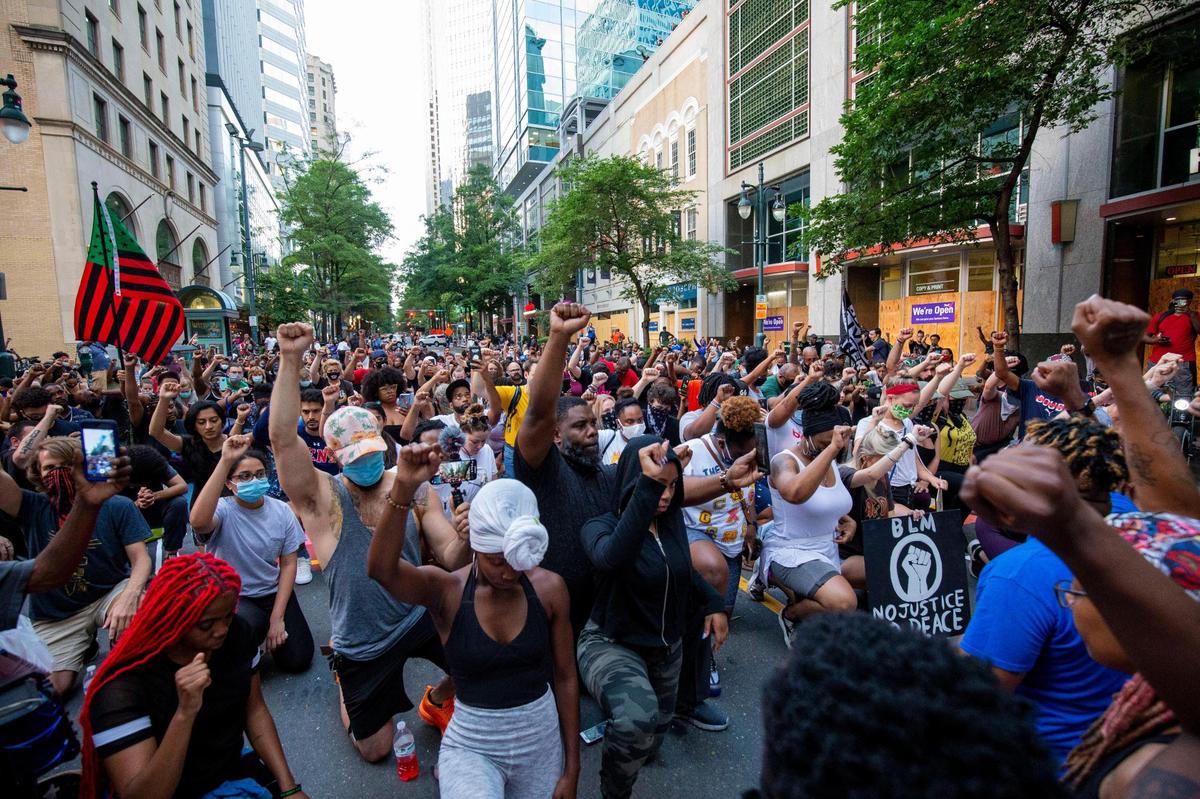 Demonstrators gather on South Tryon to take a knee for nine minutes in protest of George Floyd’s death. The street quickly became the center of attention after 17 artists painted “Black Lives Matter” along the street Tuesday.