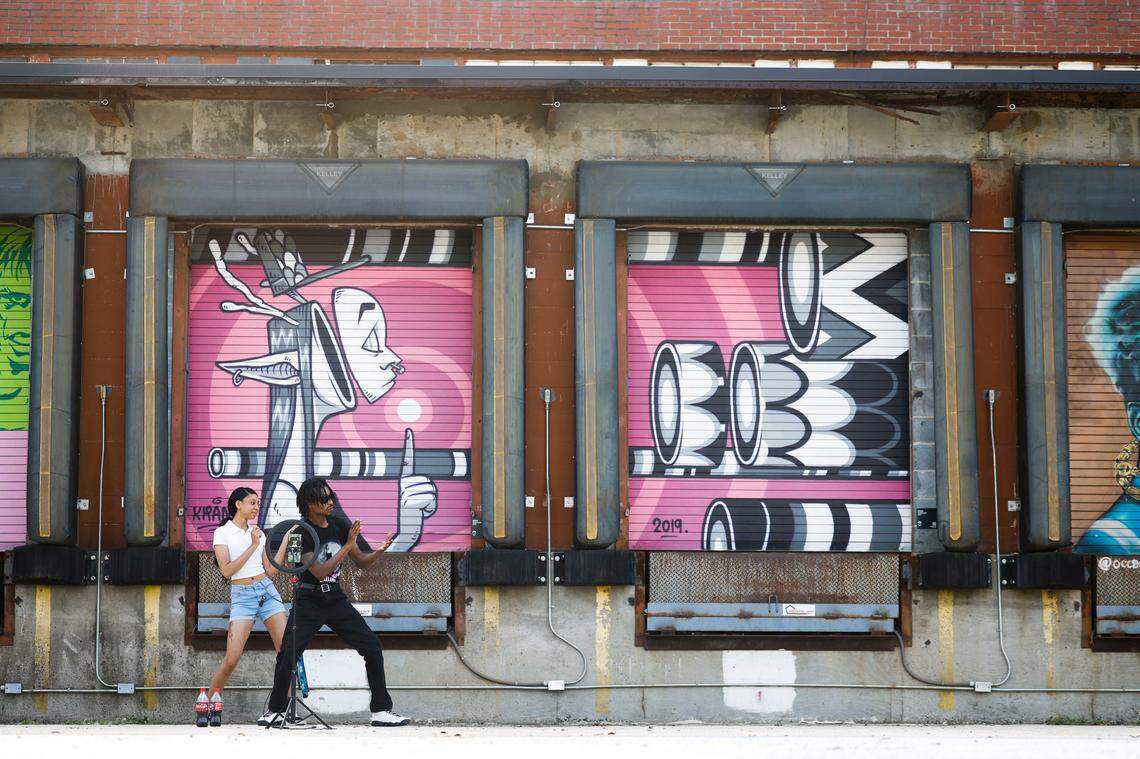 Shaniya Carson, left, and Andre Howie both of Charlotte, dance to make TikTok videos in front of murals at Camp North End. The pair try to make videos at Camp North End as much as possible for the unique scenery.