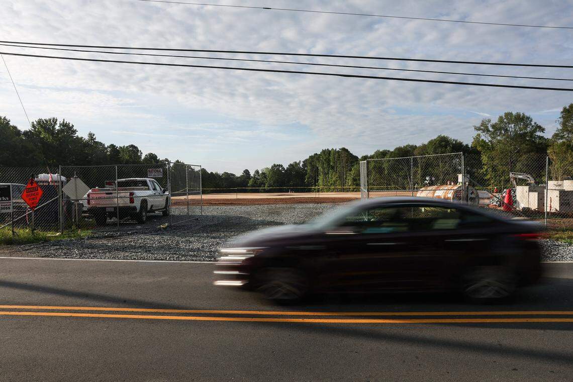 A car drives by the construction site for a new police station on Mt. Holly-Huntersville Road, which has been one of the many sources of traffic congestion along this two-lane, almost 15-mile road in Charlotte, NC. Residents who live in the area have been asking for improvements, mainly to widen the road to accommodate the growth.