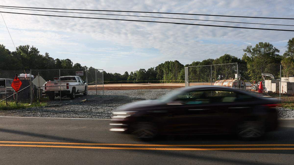 A car drives by the construction site for a new police station on Mt. Holly-Huntersville Road, which has been one of the many sources of traffic congestion along this two-lane, almost 15-mile road in Charlotte, NC. Residents who live in the area have been asking for improvements, mainly to widen the road to accommodate the growth.