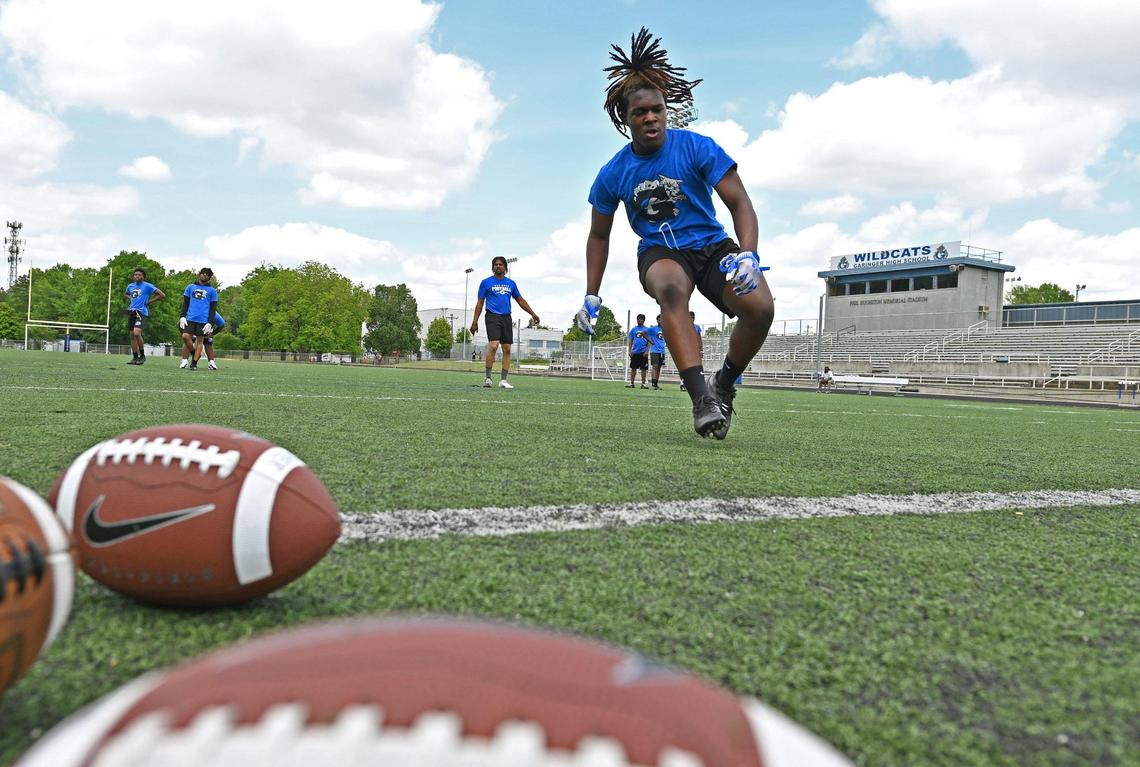 Members of the Garinger High School football team run through drills during a workout on Tuesday, April 29, 2025.