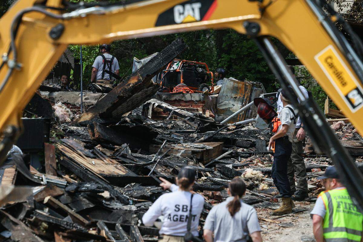 Charlotte Fire Department officials work at the site of a house fire near Freedom Park after an explosion was reported early morning in Charlotte, NC on Friday, May 2, 2025.