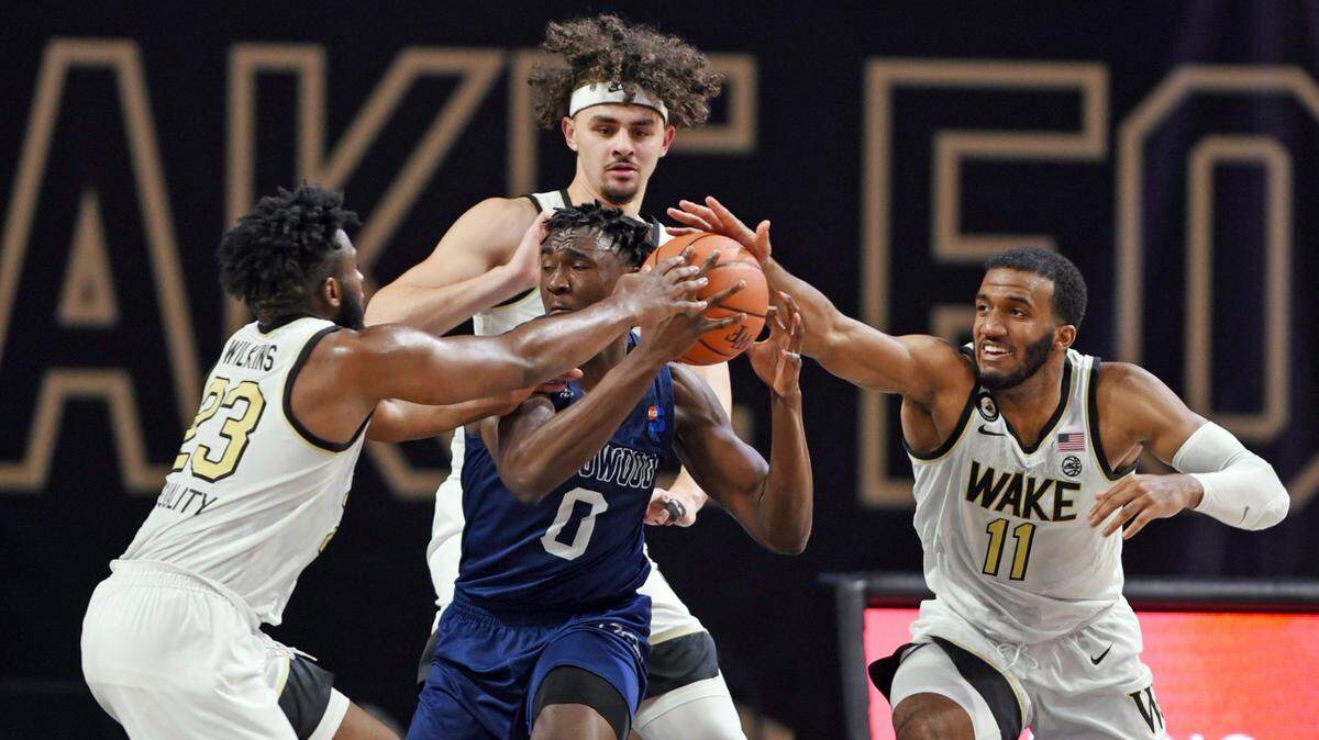 Wake Forest’s Isaiah Wilkins (23), Ismael Massoud and Ian DuBose (11) pressure Longwood’s Leslie Nkereuwem during an NCAA basketball game Friday, Nov. 27, 2020, in Winston-Salem, N.C. (Walt Unks/The Winston-Salem Journal via AP, Pool)