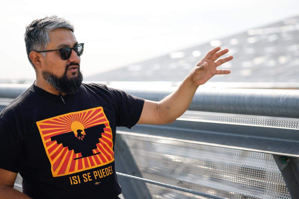 Isael Mejia, an organizer with the International Association of Ironworkers, observes construction at Charlotte Douglas International Airport and explains the dangers construction workers face when they work at great heights.