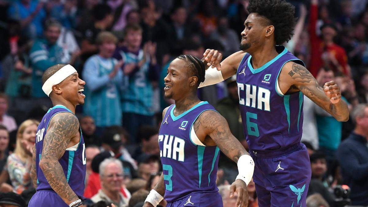 Charlotte Hornets guard Isaiah Thomas, left and forward Jalen McDaniels, right, congratulate guard Terry Rozier, center, on his three-point baskets against the Washington Wizards at Spectrum Center in Charlotte, NC on Sunday, April 10, 2022. Rozier scored 25 points in the game, with 18 coming in his 7-for-7 fourth quarter. The Hornets defeated the Wizards 124-108 to finish their season 43-39.