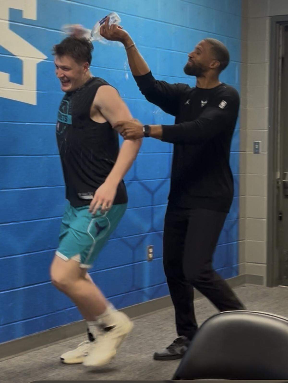 Kon Knueppel (left) gets a surprise water bath from Charlotte Hornets coach Charles Lee on April 2, 2026, after Knueppel broke the team record for three-pointers in a season. Knueppel ended the game with 261 3-pointers for the season, breaking Kemba Walker’s mark of 260.