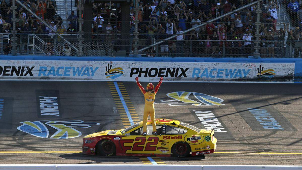Driver Joey Logano stands on his race car at the start-finish line as he celebrates after winning the NASCAR Cup Series auto race at Phoenix Raceway, Sunday, March 8, 2020, in Avondale, Ariz. (AP Photo/Ralph Freso)