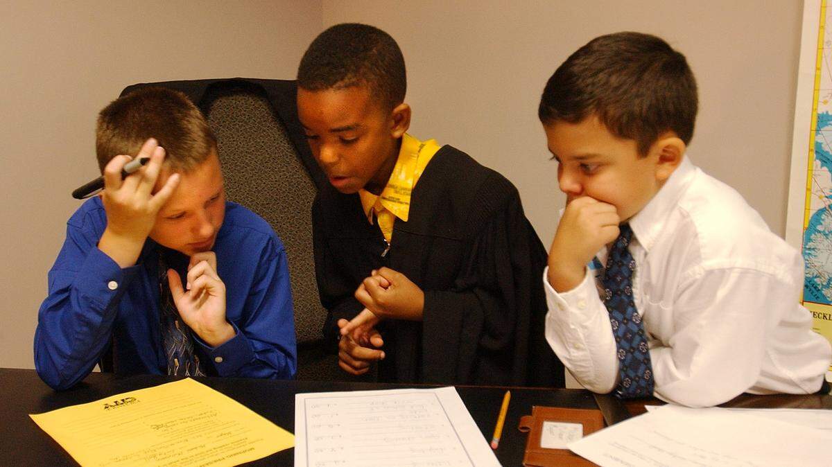 05/22/02: Fourth graders from Winding Springs Elementary acted as mayor, Michael Mullman (CQ, left),10; judge, Brandon Woods (CQ center in robes), 10 and city attorney, Thor Draper (CQ, yes as in the nordic thunder god, right in white shirt), 10, for the day at Exchange City a new Junior Achievement program. The boys helped each other work on their speeches to the other students. Junior Achievement exposes school children to economic basics by simulating business experiences. J.A. is in the news because it’s one of the programs Eric smith has recommended axing as part of his cuts. Junior Achievement held a new program, called Exchange city, which is a simulated city built for kids and run by them. The students assume various roles, business owners, customers, employees and government officials. (JOHN D. SIMMONS/STAFF)