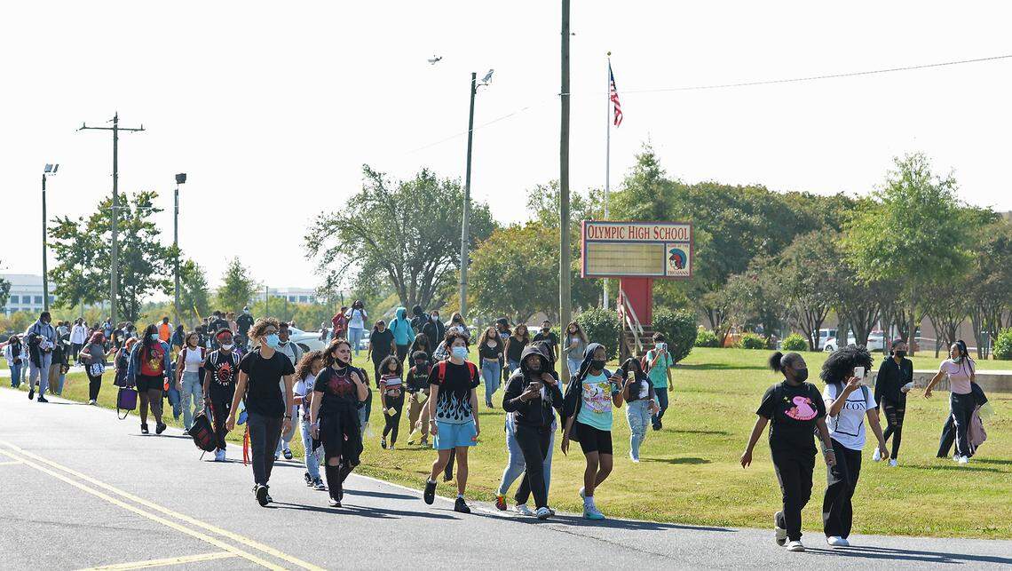 Olympic High students line both sides of Sandy Porter Road in protest outside the school on Oct. 1, 2021 in Charlotte. On Sept. 13, a 15-year-old student was charged with sexual assault of a female student. Another student, a football player, had been accused of assault and told to wear an ankle monitor. The athlete played in a recent football game wearing the monitor.
