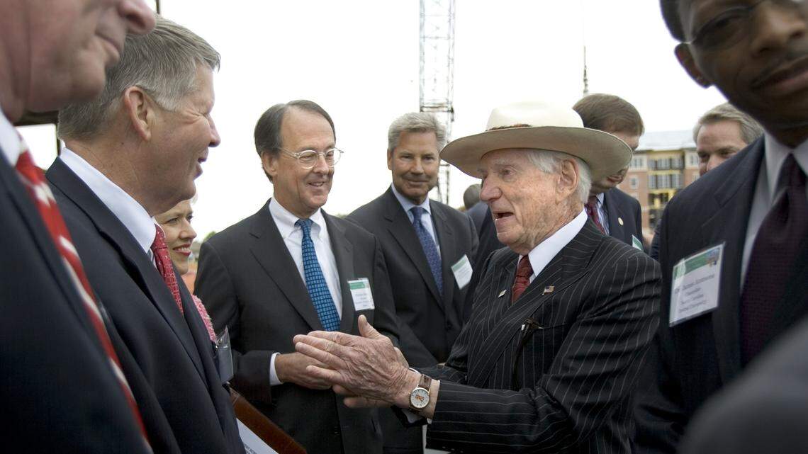 Kannapolis billionaire David Murdock’s long-running control of the Dole Food Company will end when the firm merges this year with Total Produce, an Irish firm. In a file photo, Murdock, center-right, talks with state politicians in front of the UNC Nutrition Research Institute at the North Carolina Research Campus in Kannapolis.
