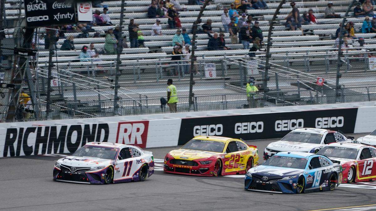 Denny Hamlin (11) leads Joey Logano (22) and Martin Truex Jr. (19) during a restart after a caution during the NASCAR Cup Series auto race at Richmond International Raceway in Richmond, Va., Sunday, April 18, 2021. (AP Photo/Steve Helber)