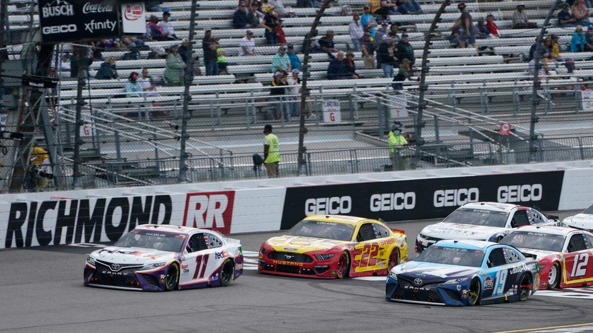 Denny Hamlin (11) leads Joey Logano (22) and Martin Truex Jr. (19) during a restart after a caution during the NASCAR Cup Series auto race at Richmond International Raceway in Richmond, Va., Sunday, April 18, 2021. (AP Photo/Steve Helber)
