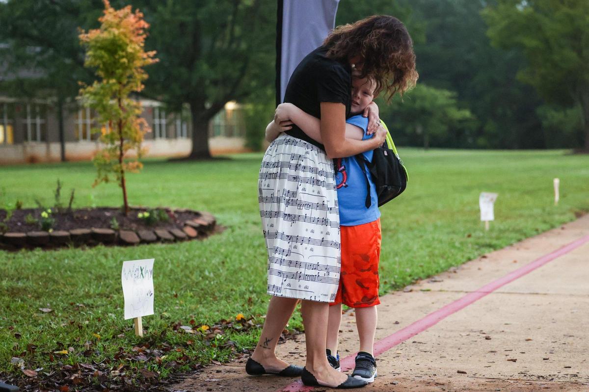 Classroom music teacher Emily Rhodes, left, hugs a student as he arrives for the frist day of school at Waxhaw Elementary School on Monday, August 28, 2023.