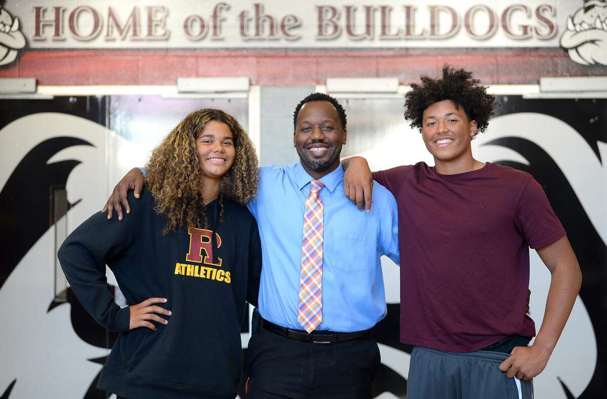 (L-R) Ella, Dennis and Daevin Hobbs on Monday, November 15, 2021. Ella is a top 20 ranked girls basketball player in the class of 2024. Daevin is a power five football recruit. Dennis is the principal at Jay M. Robinson High School.