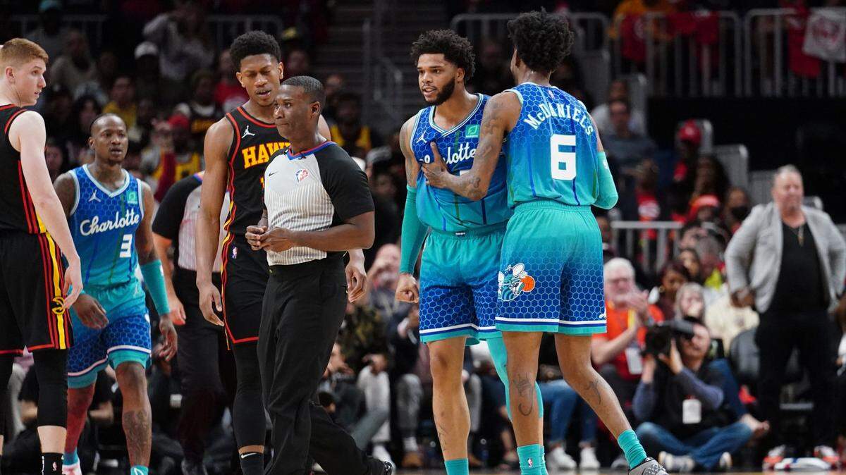 Charlotte Hornets forward Miles Bridges (0) is restrained by guard James Bouknight (5) as he argues a foul call in the second half of an NBA play-in basketball game against the Atlanta Hawks Wednesday, April 13, 2022, in Atlanta. (AP Photo/John Bazemore)