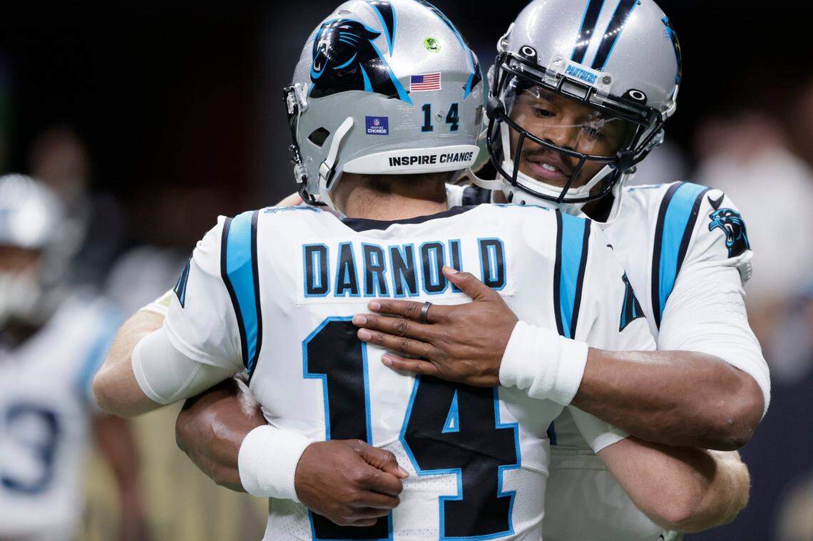 Carolina Panthers quarterback Sam Darnold (14) hugs quarterback Cam Newton before an NFL football game against the New Orleans Saints in New Orleans, Sunday, Jan. 2, 2022.