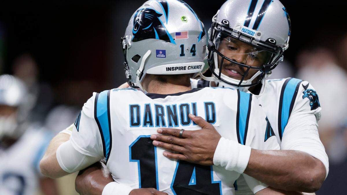 Carolina Panthers quarterback Sam Darnold (14) hugs quarterback Cam Newton before an NFL football game against the New Orleans Saints in New Orleans, Sunday, Jan. 2, 2022.