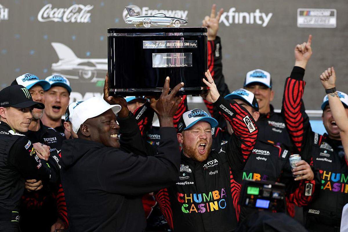 Tyler Reddick, driver of the #45 Chumba Casino Toyota, and Michael Jordan, NBA Hall of Famer and co-owner of 23XI Racing lift the Harley J. Earl Trophy in victory lane after winning the NASCAR Cup Series Daytona 500 at Daytona International Speedway on Feb. 15, 2026 in Daytona Beach, Florida.