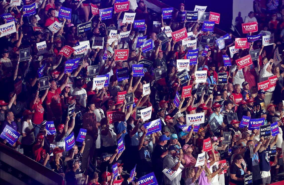 Supporters of former President Donald Trump raise their campaign signs high in the air during a rally at Bojangles Coliseum in Charlotte, NC on Wednesday, July 24, 2024.