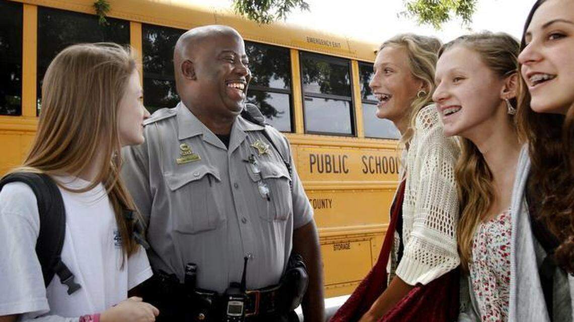 Wake County Sheriff’s Deputy Sharron Bass, center, talks with seventh-graders, from left, Abbie Smith, Emma Wilkins, Rachel Strawn and Anabel Russo while he oversees dismissal outside of Ligon Middle School in Raleigh in this 2014 file photo.