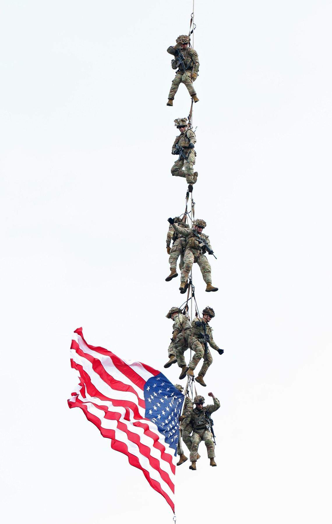 U.S. Army Fort Campbell Blackhawk Demo members are transported from Charlotte Motor Speedway carrying an American flag prior to the running of the Coca-Cola 600 in Concord, NC on Sunday, May 26, 2024.