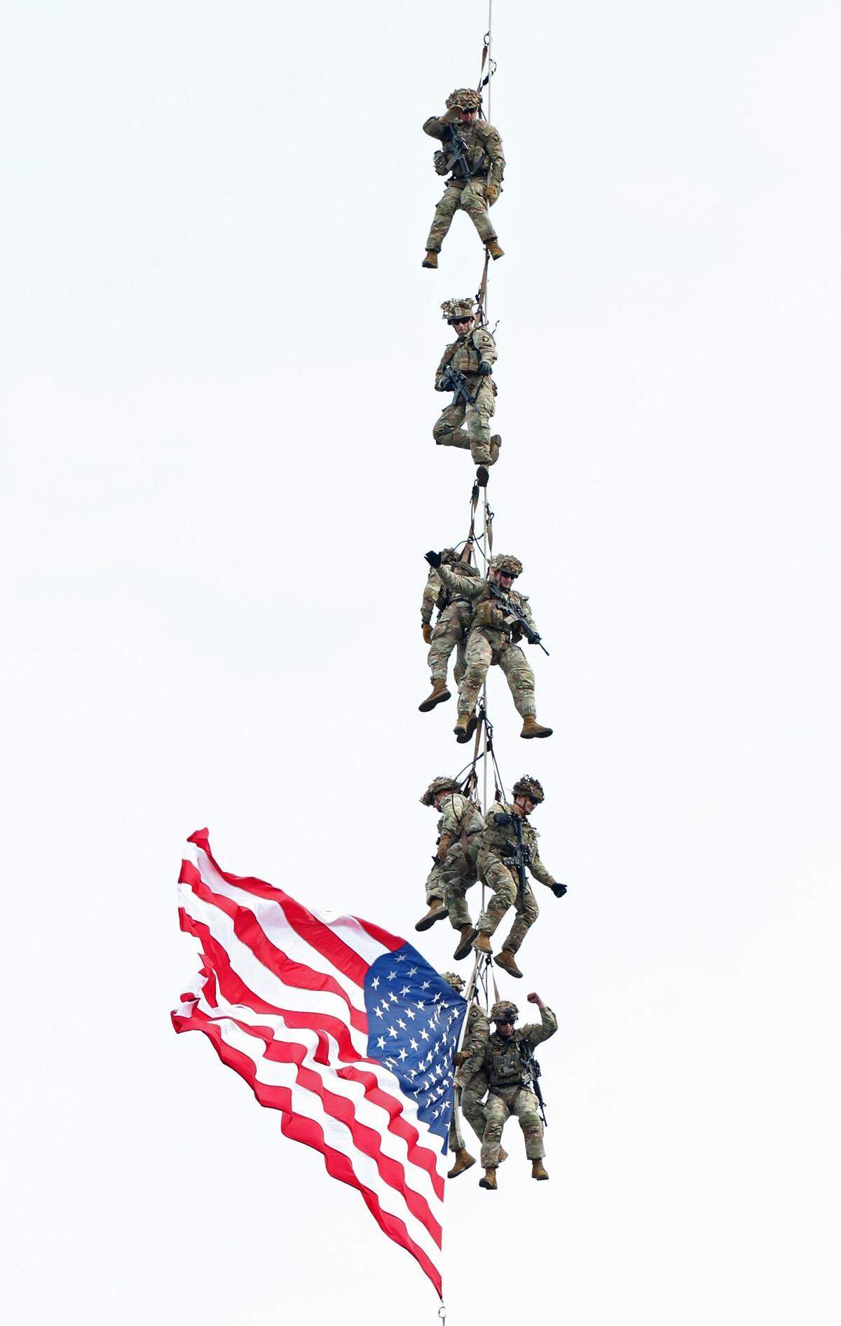 U.S. Army Fort Campbell Blackhawk Demo members are transported from Charlotte Motor Speedway carrying an American flag prior to the running of the Coca-Cola 600 in Concord, NC on Sunday, May 26, 2024.