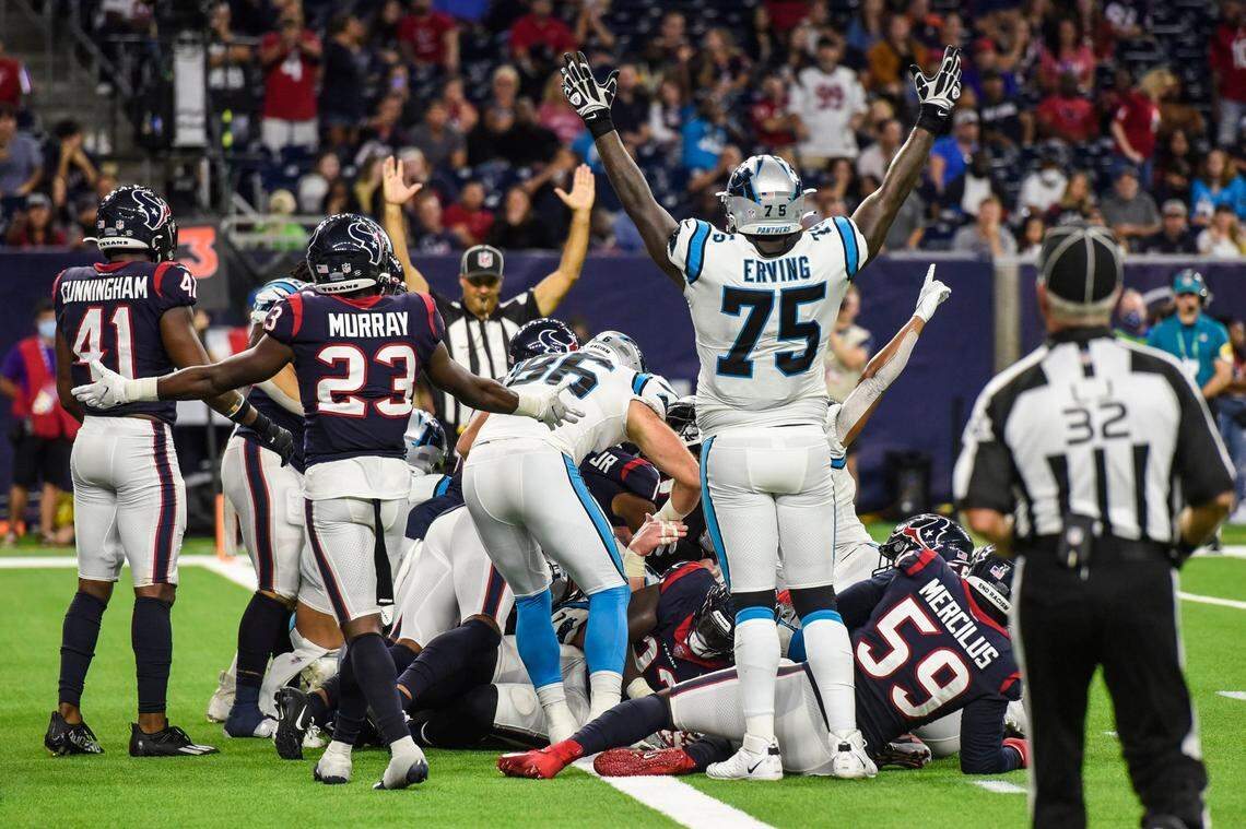 Panthers tackle Cameron Erving, front center, mirrors a referee by holding his arms up to signify a touchdown after quarterback Sam Darnold pushed his way into the end zone during the game at NRG Stadium on Thursday, September 23, 2021 in Houston, TX. The Panthers beat the Texans 24-9, giving them their third win in a row to start the season.