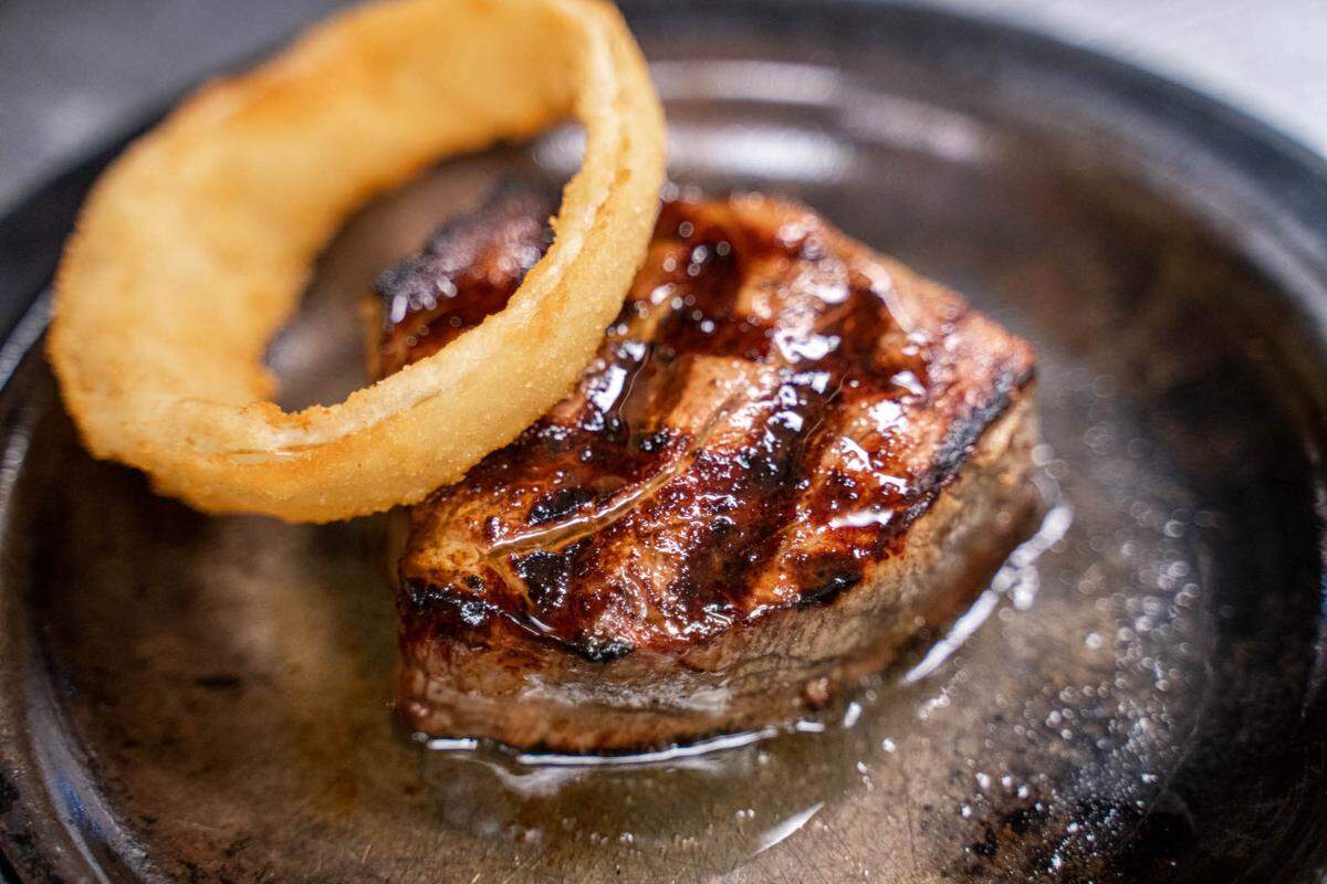 A filet with an onion ring at Beef ‘N Bottle.