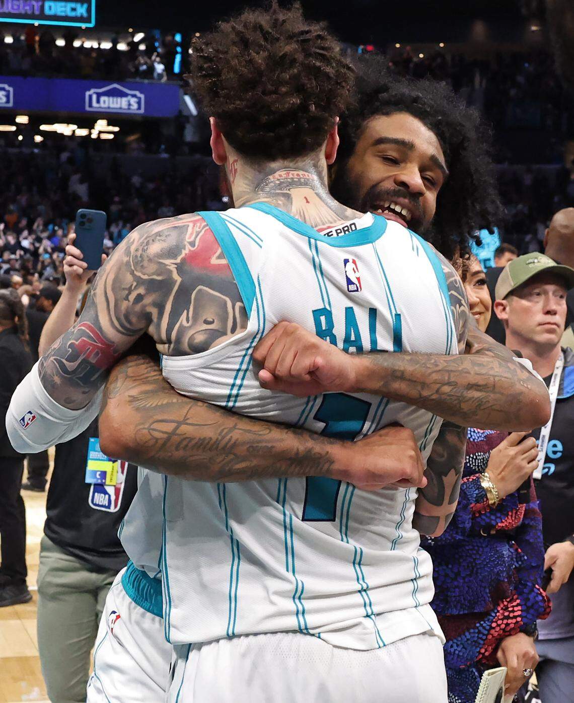 Charlotte Hornets guards LaMelo Ball, left and Coby White, right, hug following the team's win over the Miami Heat at Spectrum Center in Charlotte, NC on Tuesday, April 14, 2026. The Hornets defeated the Heat 127-126 in NBA Play-in-Tournament basketball game. Ball hit the game winning shot on a layup in the closing seconds.