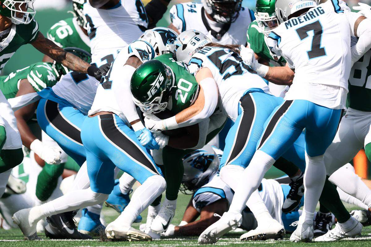 New York Jets running back Breece Hall (20) is tackled by Carolina Panthers linebacker Christian Rozeboom (56) in the first quarter of Sunday’s game in New Jersey.