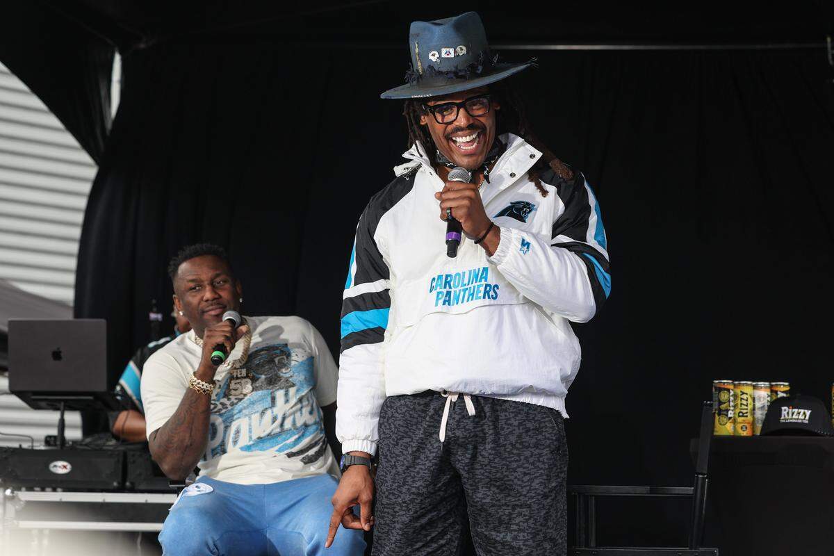 Cam Newton tells a story about former teammate and friend Thomas Davis Sr., during the taping of the podcast “4th & 1” at the Roaring Riot tailgate before the wild card playoff game in Charlotte on Saturday, Jan. 10, 2026.