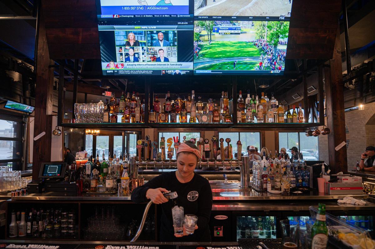 A bartender at The Office blasts a glass with a quick shot of sparkling water.