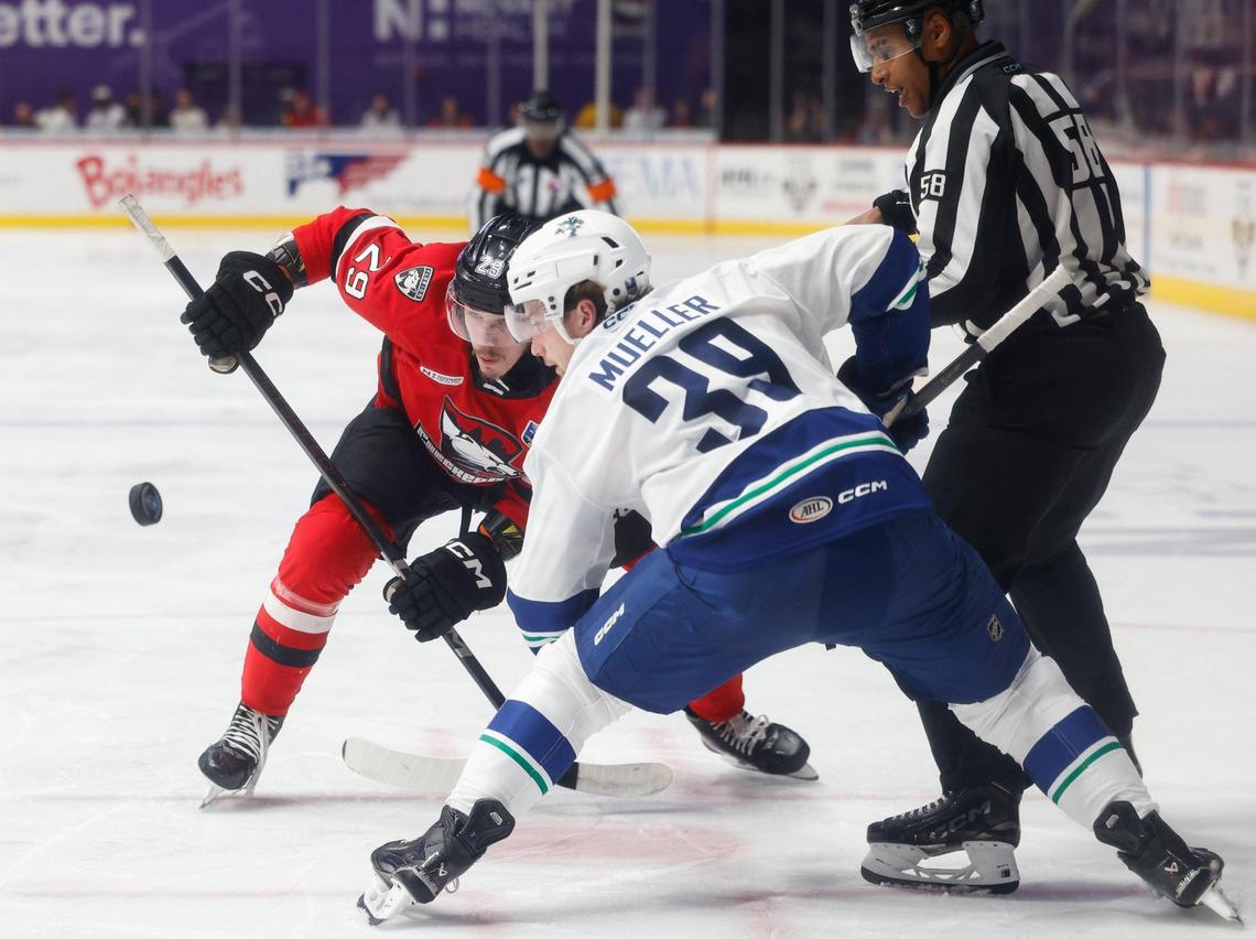 Checkers forward Sandis Vilmanis, back, and Canucks center Ty Mueller eye the puck in a face-off during the Calder Cup opener at Bojangles Coliseum in Charlotte, NC on Friday, June 13, 2025.