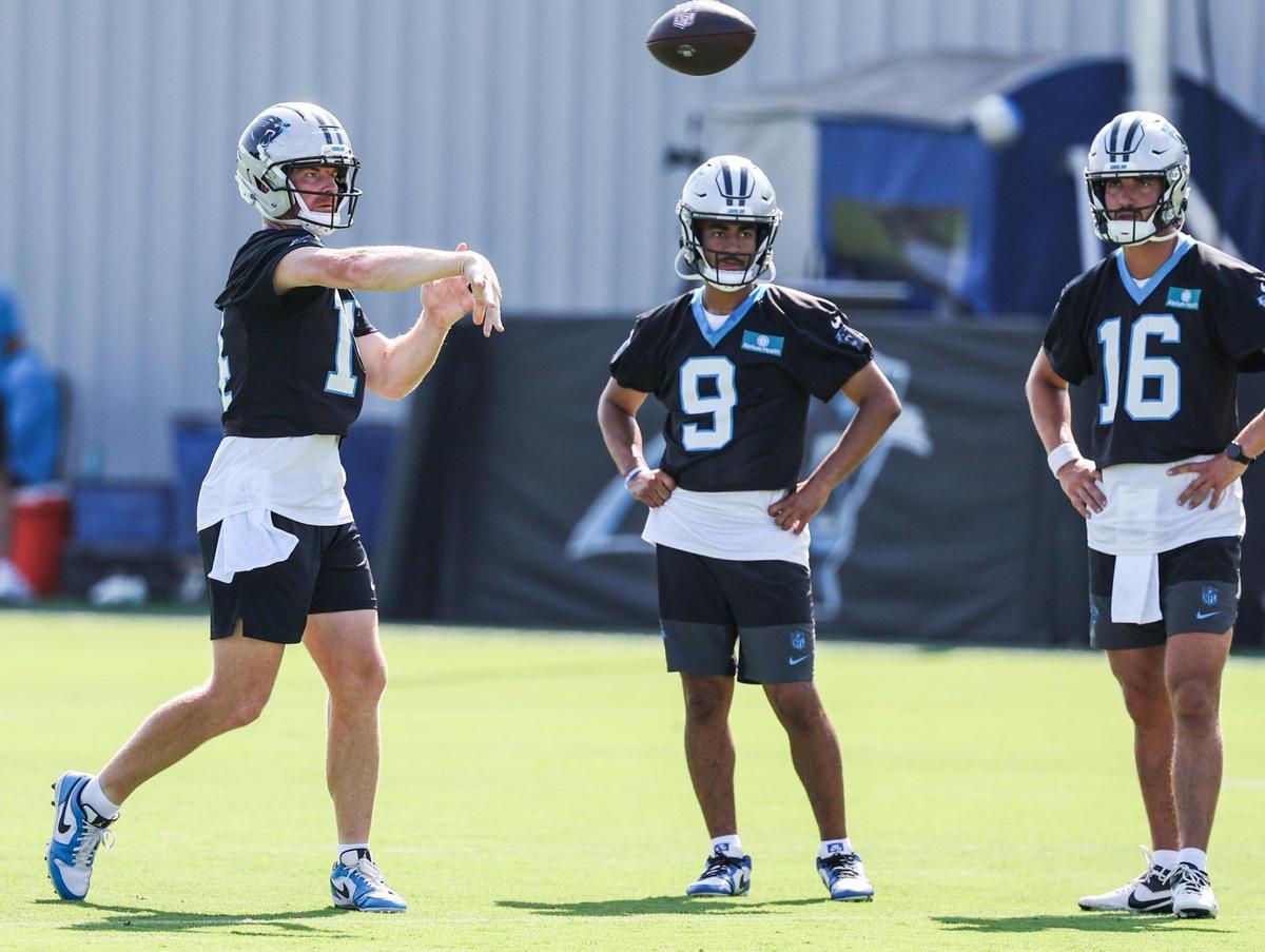 Panthers quarterback Andy Dalton, left, throws a pass as fellow quarterbacks Bryce Young, center, and Jack Plummer watch during training camp in Charlotte, NC on Wednesday, July 24, 2025.
