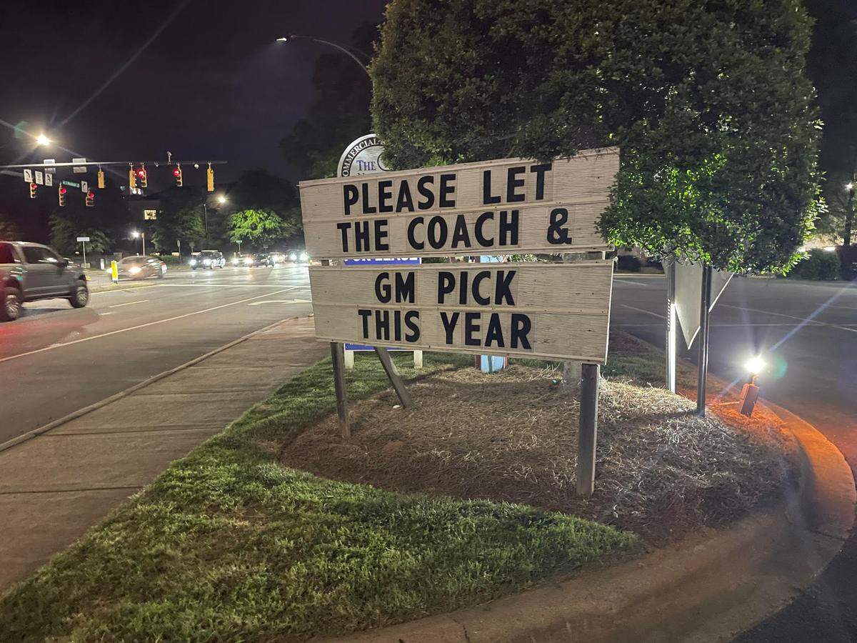 A sign directed at Carolina Panthers owner David Tepper regarding the NFL Draft, sits outside Dilworth Neighborhood Grille in Charlotte in April 2024.