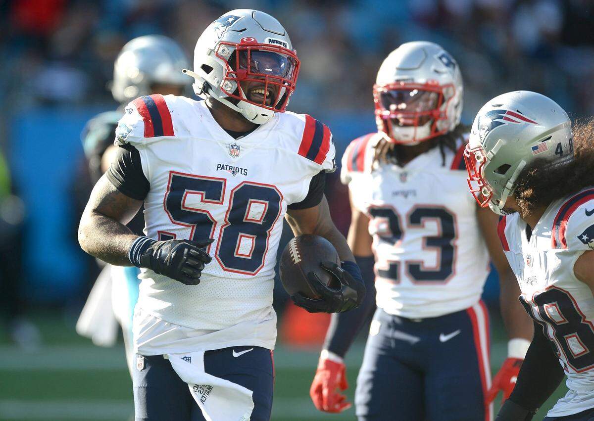 New England Patriots linebacker Jamie Collins Sr., left, smiles as he is congratulated following his tackle of Carolina Panthers running back Christian McCaffrey during third quarter action at Bank of America Stadium in Charlotte, NC on Sunday, November 7, 2021. The Patriots defeated the Panthers 24-6.