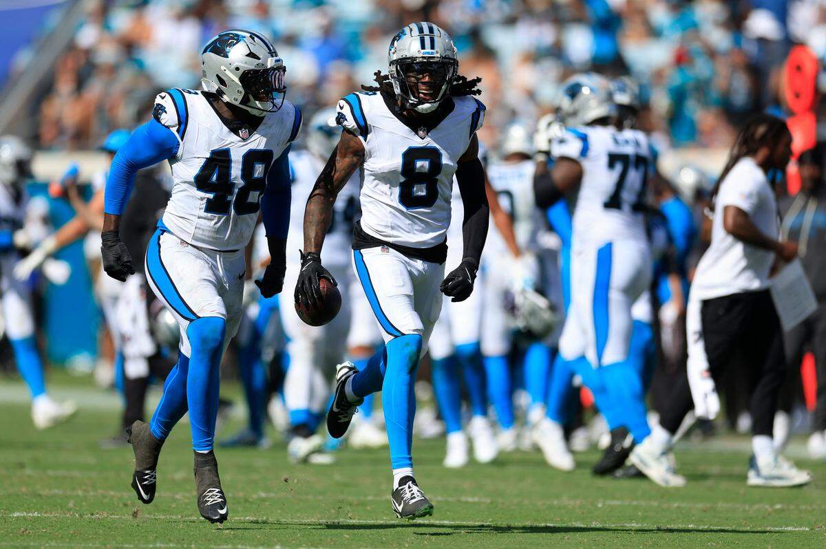 Carolina Panthers cornerback Jaycee Horn (8) reacts to collecting an interception as linebacker Thomas Incoom (48) cheers on during the third quarter of an NFL football matchup at EverBank Stadium, Sunday, Sept. 7, 2025 in Jacksonville, Fla. The Jaguars defeated the Panthers 26-10. [Corey Perrine/Florida Times-Union]