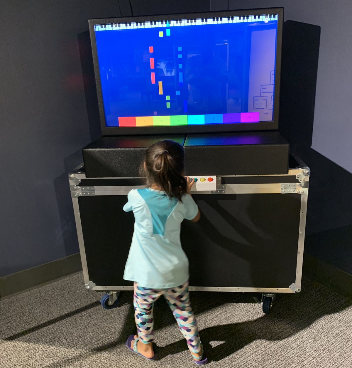 A young girl plays the Piano Genie at the Orlando Science Center, when the artificial intelligence exhibit debuted there in 2019. Piano Genie will be part of the Discovery Place exhibit, too. It interprets real-time notes and chords to create a tune.