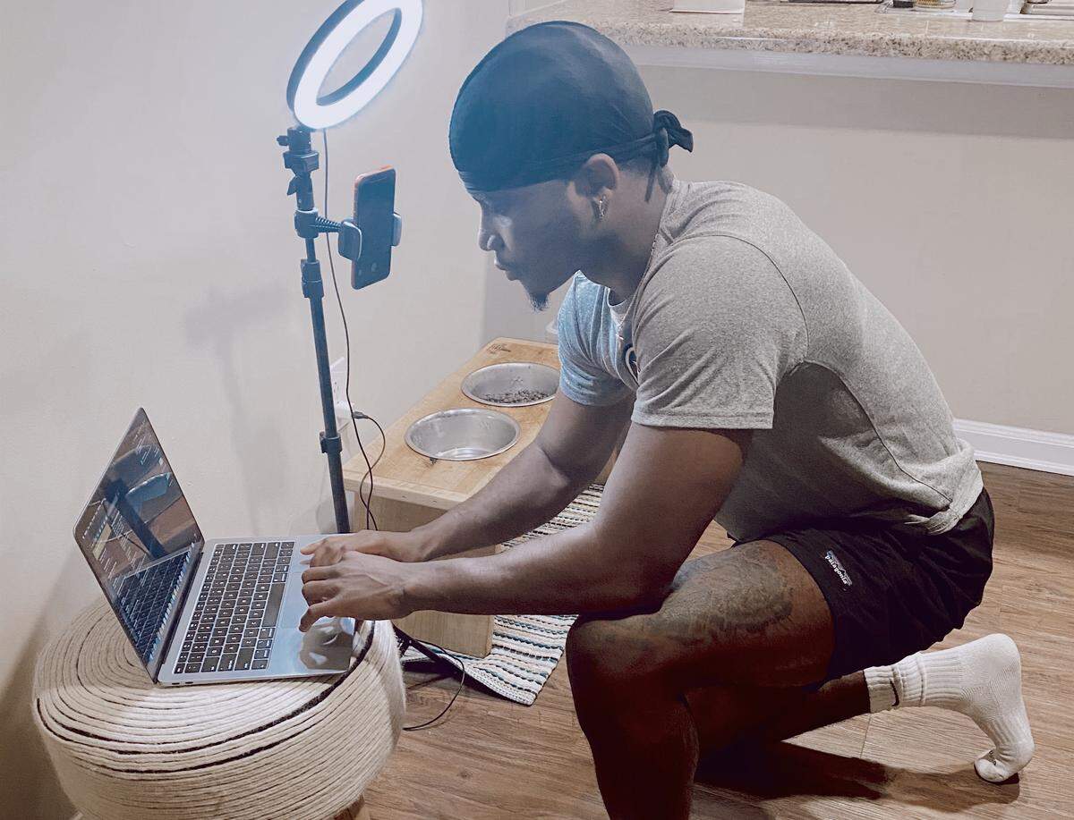Giavonni Mack, a personal trainer at Building Bodies, has set up his living room for video calls with clients.