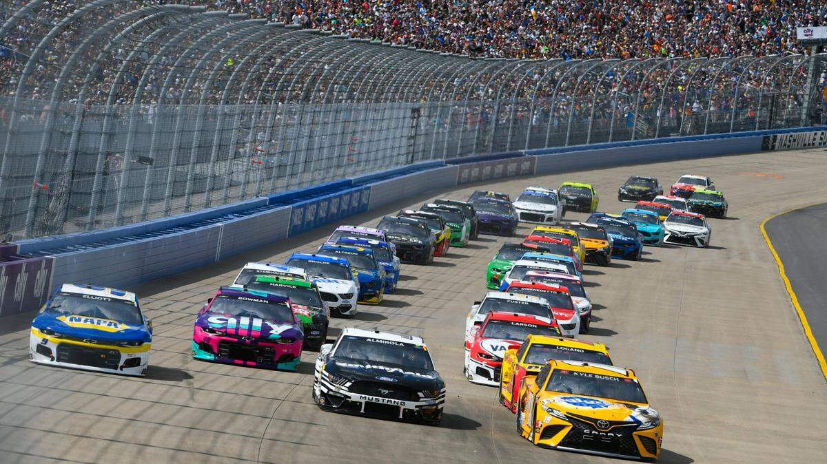 Chase Elliott, left, Aric Almirola, center, and Kyle Busch, right, lead as a NASCAR Cup Series auto race starts, Sunday, June 20, 2021, in Lebanon, Tenn. (AP Photo/John Amis)