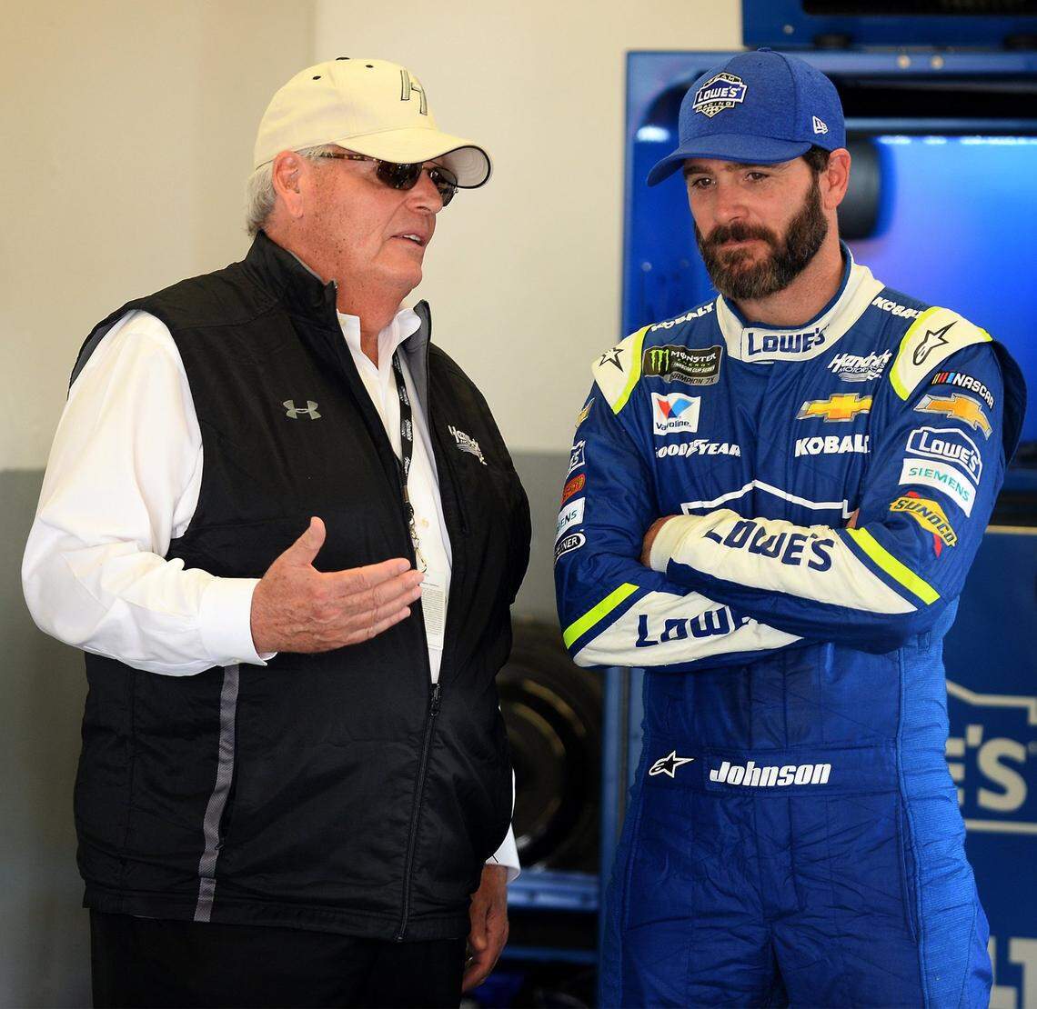 NASCAR team owner Rick Hendrick, left, talks with driver Jimmie Johnson, right, in the garage at Daytona International Speedway on Friday, February 24, 2017.