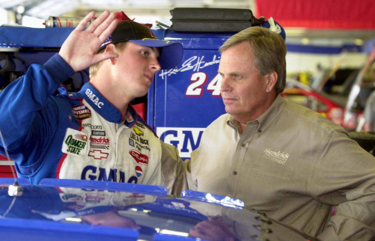 In 2001, NASCAR driver Ricky Hendrick (left) talked with his father, Rick Hendrick at Charlotte Motor Speedway. Rick Hendrick had imagined that Ricky would be running Hendrick Motorsports by now, but Ricky was killed in a plane crash in 2004.
