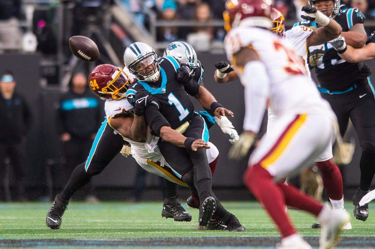 Panthers quarterback Cam Newton tries to get rid of the ball as the Washington Football Team defense latches on.